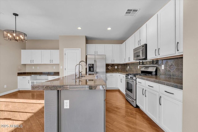 kitchen featuring white cabinetry, sink, a kitchen island with sink, light hardwood / wood-style floors, and stainless steel appliances