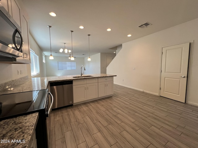 kitchen with white cabinetry, sink, pendant lighting, appliances with stainless steel finishes, and light wood-type flooring