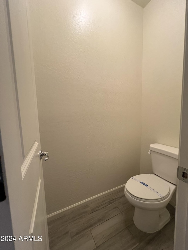 bathroom with hardwood / wood-style floors and toilet