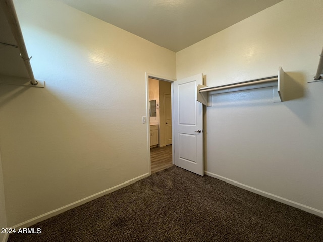 walk in closet featuring dark carpet