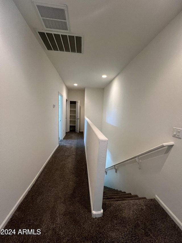 hallway featuring dark carpet