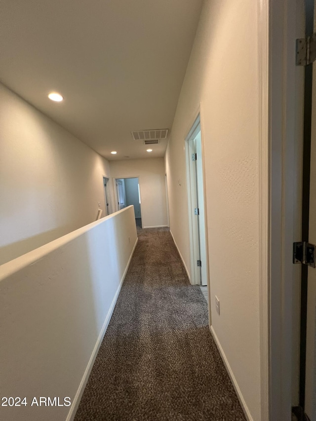 hallway featuring dark carpet