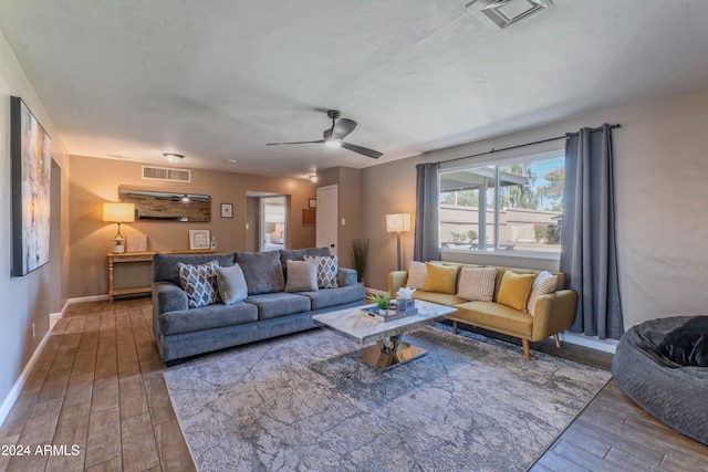 living room featuring baseboards, visible vents, and wood finished floors