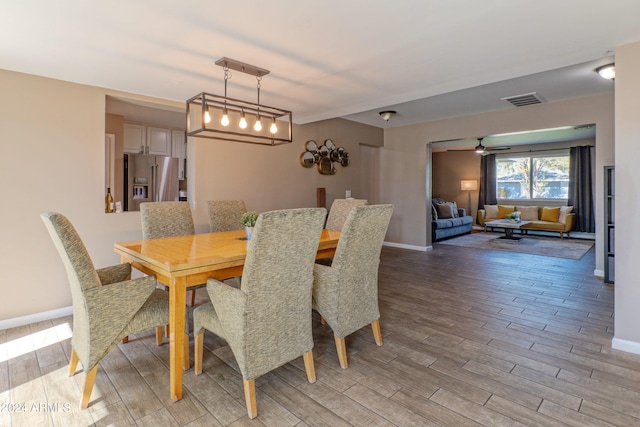 dining room with light wood-style flooring, visible vents, ceiling fan, and baseboards