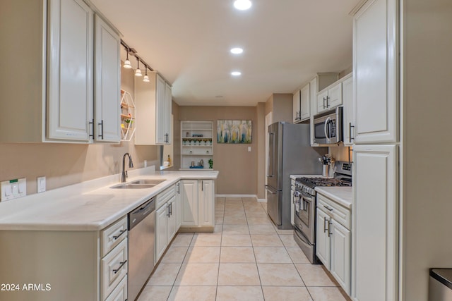 kitchen with light countertops, stainless steel appliances, white cabinetry, a sink, and light tile patterned flooring