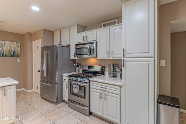 kitchen featuring light tile patterned floors, visible vents, white cabinets, light countertops, and appliances with stainless steel finishes