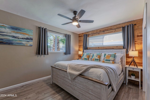 bedroom featuring a ceiling fan, baseboards, and wood finished floors