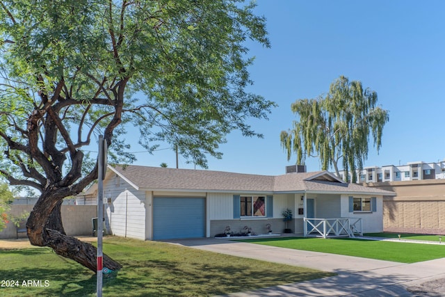 ranch-style home featuring concrete driveway, a front lawn, an attached garage, and fence