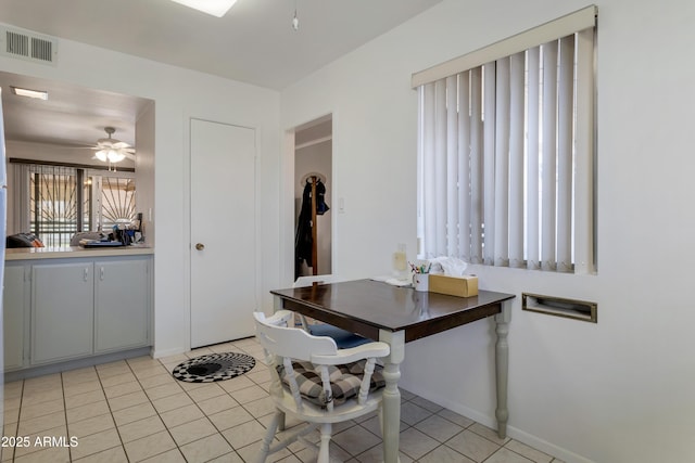 dining area with light tile patterned floors, ceiling fan, visible vents, and baseboards