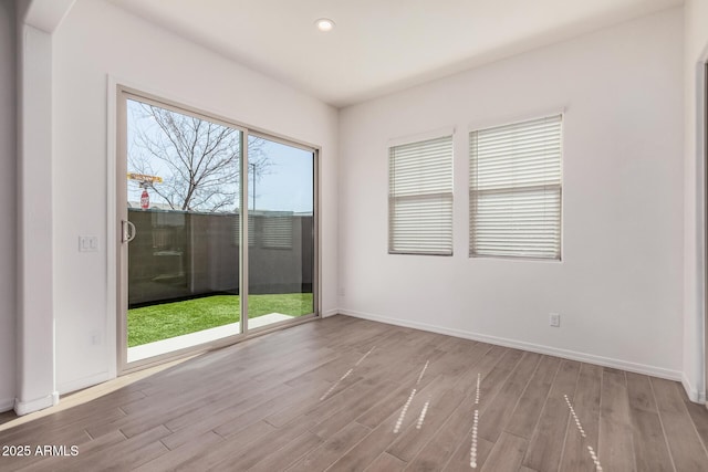 unfurnished room featuring recessed lighting, baseboards, and wood finished floors