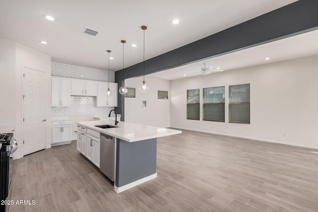 kitchen with visible vents, light wood-style flooring, appliances with stainless steel finishes, open floor plan, and a sink