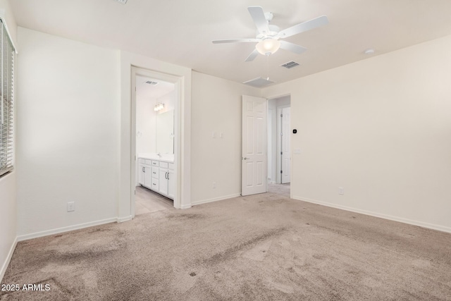 unfurnished bedroom featuring baseboards, visible vents, a ceiling fan, connected bathroom, and light colored carpet