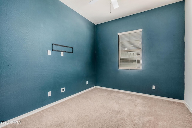 carpeted empty room with ceiling fan and baseboards