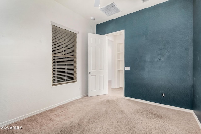 carpeted empty room featuring baseboards