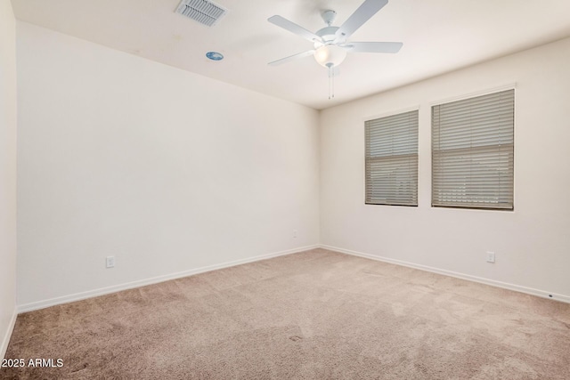 carpeted empty room featuring visible vents, ceiling fan, and baseboards