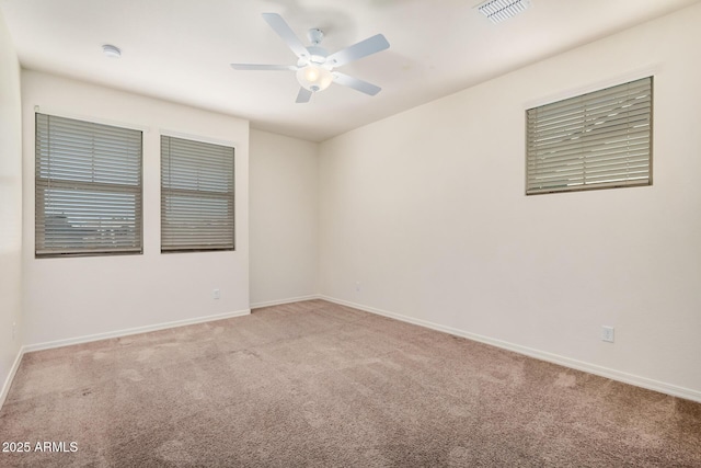 spare room featuring ceiling fan, carpet flooring, visible vents, and baseboards