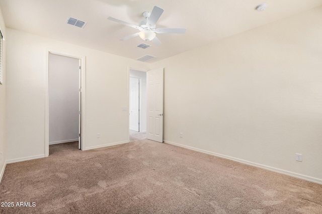 spare room featuring carpet floors, visible vents, baseboards, and a ceiling fan