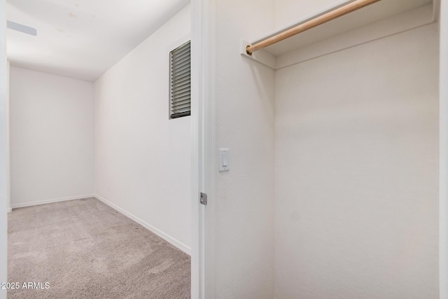 walk in closet featuring light colored carpet