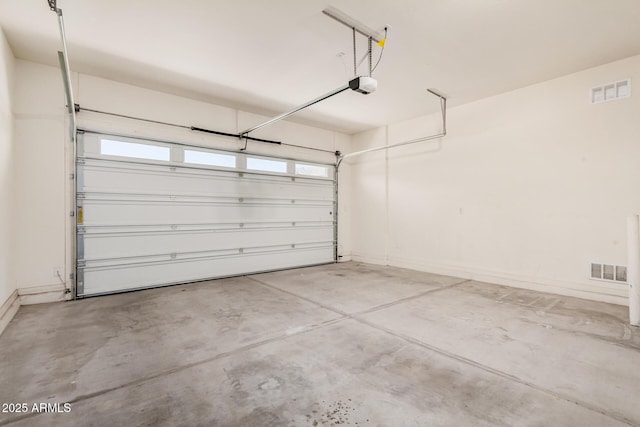 garage featuring baseboards, visible vents, and a garage door opener