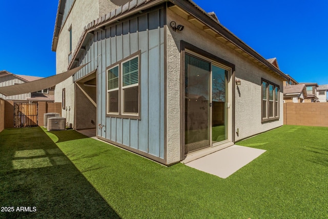 view of side of home featuring board and batten siding, a yard, and fence