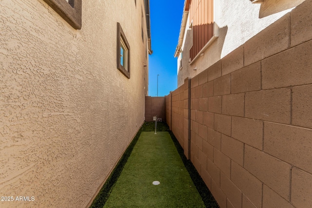 view of side of property featuring fence and stucco siding