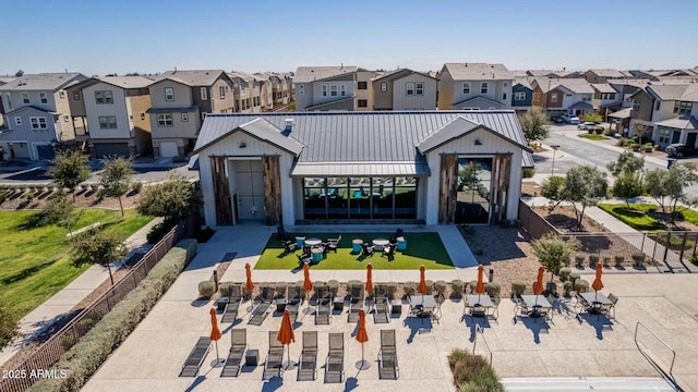 view of front facade with a residential view, a standing seam roof, metal roof, and fence