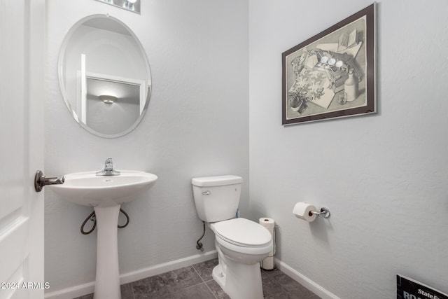 bathroom featuring tile patterned flooring, toilet, and sink