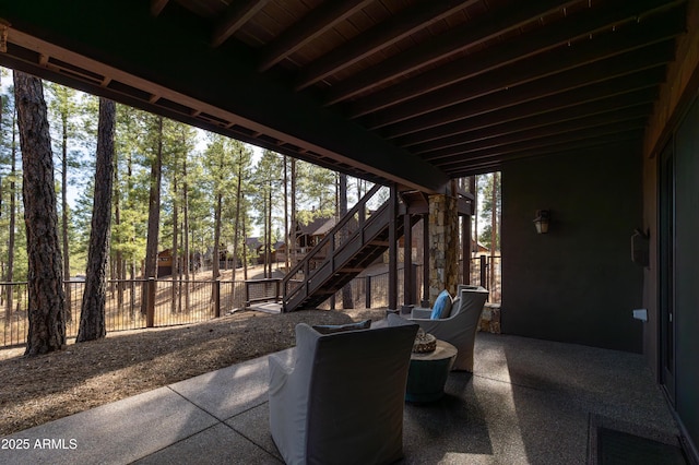 view of patio / terrace featuring fence and stairway