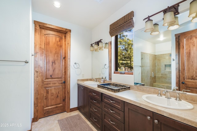 bathroom featuring a stall shower, tile patterned flooring, a sink, and double vanity