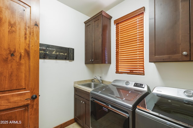 laundry area featuring baseboards, a sink, cabinet space, and washer and dryer