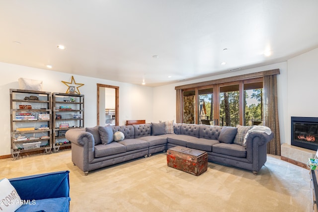 living area featuring a glass covered fireplace, visible vents, carpet, and recessed lighting