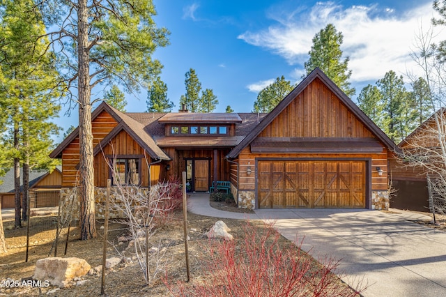 view of front facade featuring a garage, stone siding, and concrete driveway