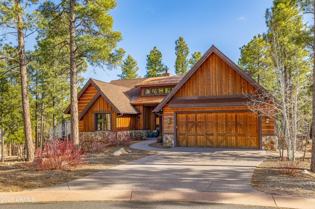 rustic home with a garage, stone siding, roof with shingles, and driveway