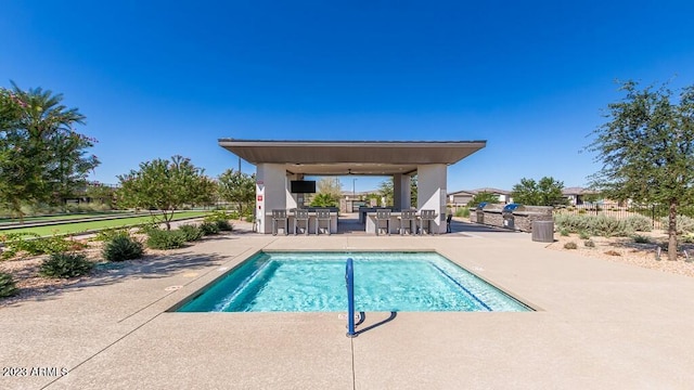 view of swimming pool featuring exterior bar and a patio area