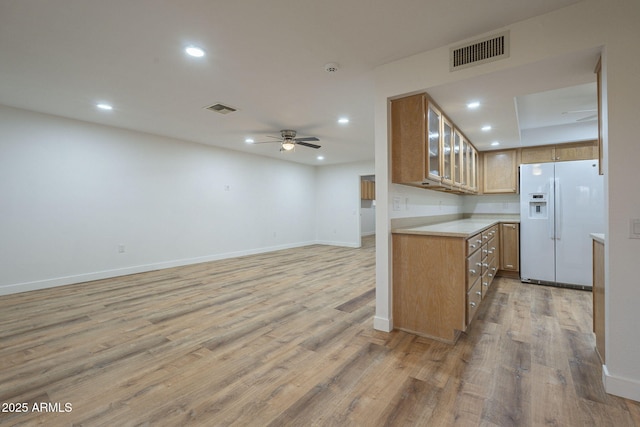 kitchen with white fridge with ice dispenser, ceiling fan, and light hardwood / wood-style flooring