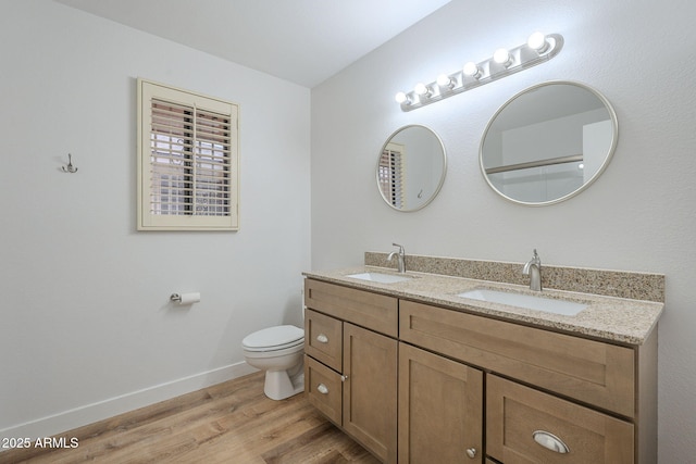 bathroom with vanity, wood-type flooring, and toilet