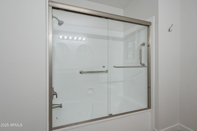 bathroom featuring bath / shower combo with glass door