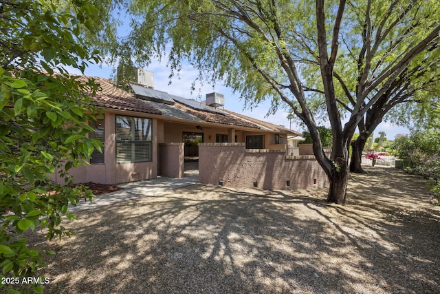 rear view of house featuring solar panels