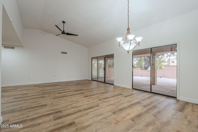 interior space featuring light hardwood / wood-style flooring, ceiling fan with notable chandelier, and vaulted ceiling