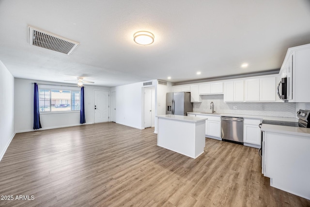 3801 E Captain Dreyfus Ave, Phoenix, AZ 85032 - kitchen featuring stainless steel appliances, a center island, ceiling fan, light wood-style floors, and open floor plan