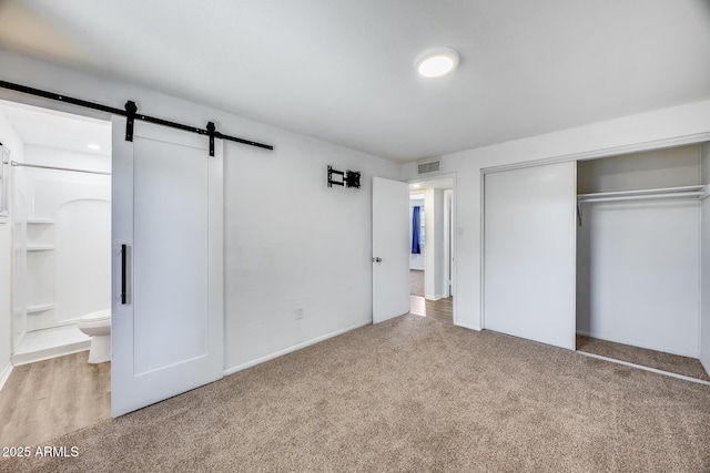 3801 E Captain Dreyfus Ave, Phoenix, AZ 85032 - unfurnished bedroom featuring a barn door, light colored carpet, a closet, and ensuite bath