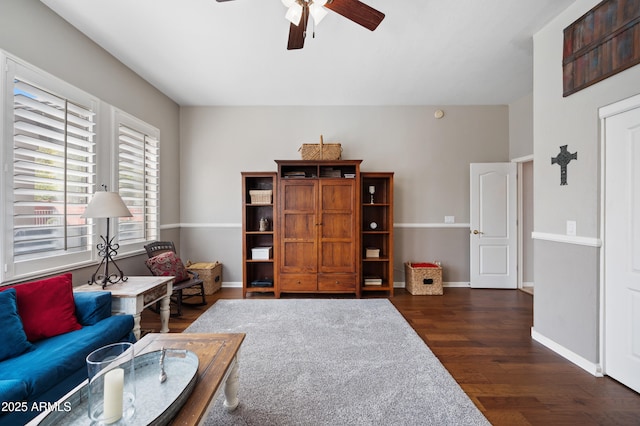 sitting room featuring a ceiling fan, baseboards, and wood finished floors