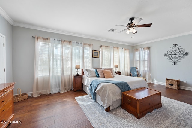 bedroom with visible vents, crown molding, baseboards, and wood finished floors