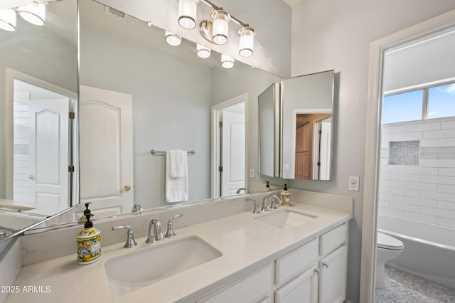 bathroom with a sink, toilet, and double vanity