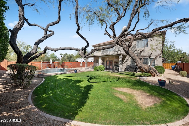 view of yard featuring a patio, french doors, fence, and a fenced in pool