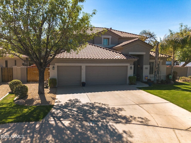 mediterranean / spanish home with a tile roof, stucco siding, concrete driveway, fence, and a garage