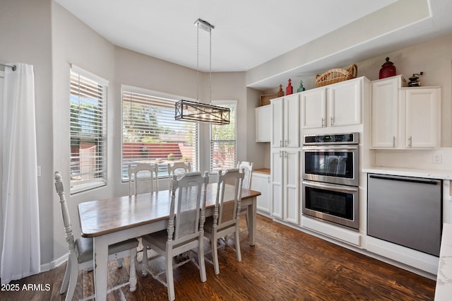 kitchen with dark wood finished floors, dishwashing machine, light countertops, stainless steel double oven, and white cabinetry