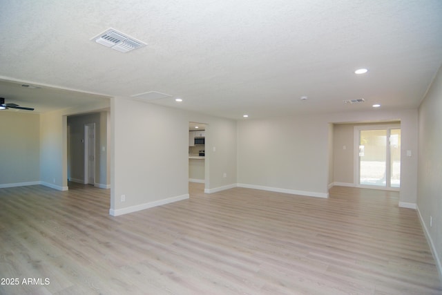 empty room with a textured ceiling, baseboards, visible vents, recessed lighting, and light wood-style floors