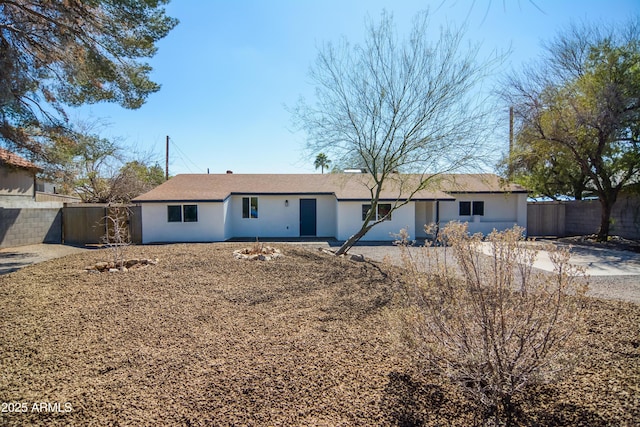 ranch-style home featuring fence