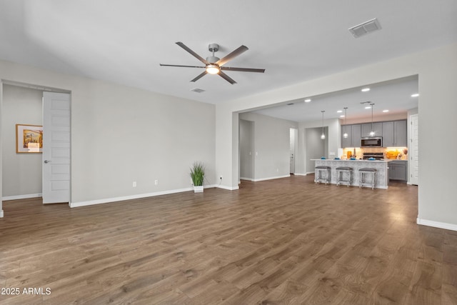19203 W Jackson St, Buckeye, AZ 85326 - unfurnished living room featuring a ceiling fan, dark wood-style flooring, baseboards, and recessed lighting